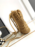 Gold crochet handbag with chain strap on a white surface